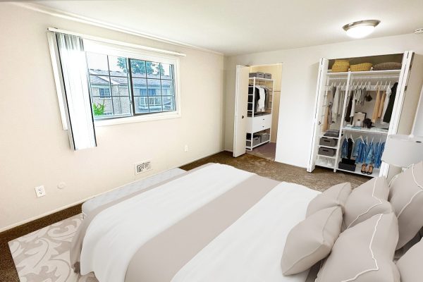 Spacious bedroom with cozy bed, open closet, and large window for natural light. Elegant decor in neutral tones.