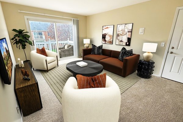 Modern living room with cozy seating, abstract art, and natural light from sliding doors leading to a balcony view.