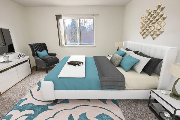 Modern bedroom with stylish decor, teal accents, large bed, art on wall.