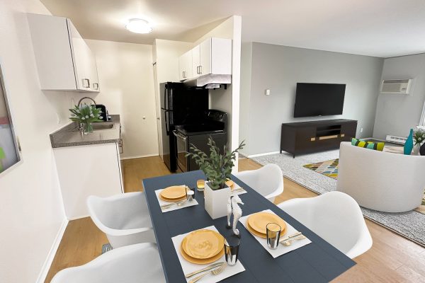 Modern open-plan kitchen and living room with dining table and stylish decor.