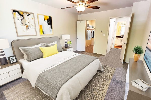 Modern bedroom with abstract art, grey and yellow accents, and walk-in closet.